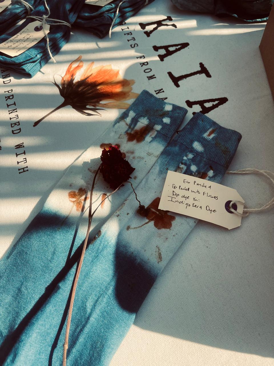 Indigo dip-dyed socks on the KAIA cloth with a handwritten botanical tag