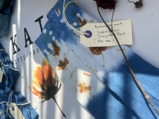 An indigo KAIA textile with a hand-written indigo and marigold botanical tag