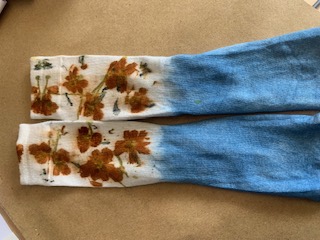 Indigo dip-dyed socks with orange marigold botanical prints laid flat