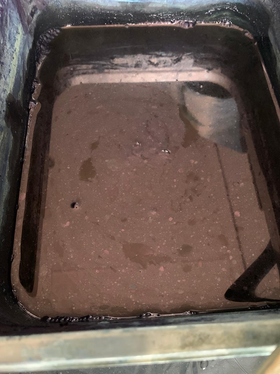 The shimmering surface of a living indigo vat, ready to receive cloth